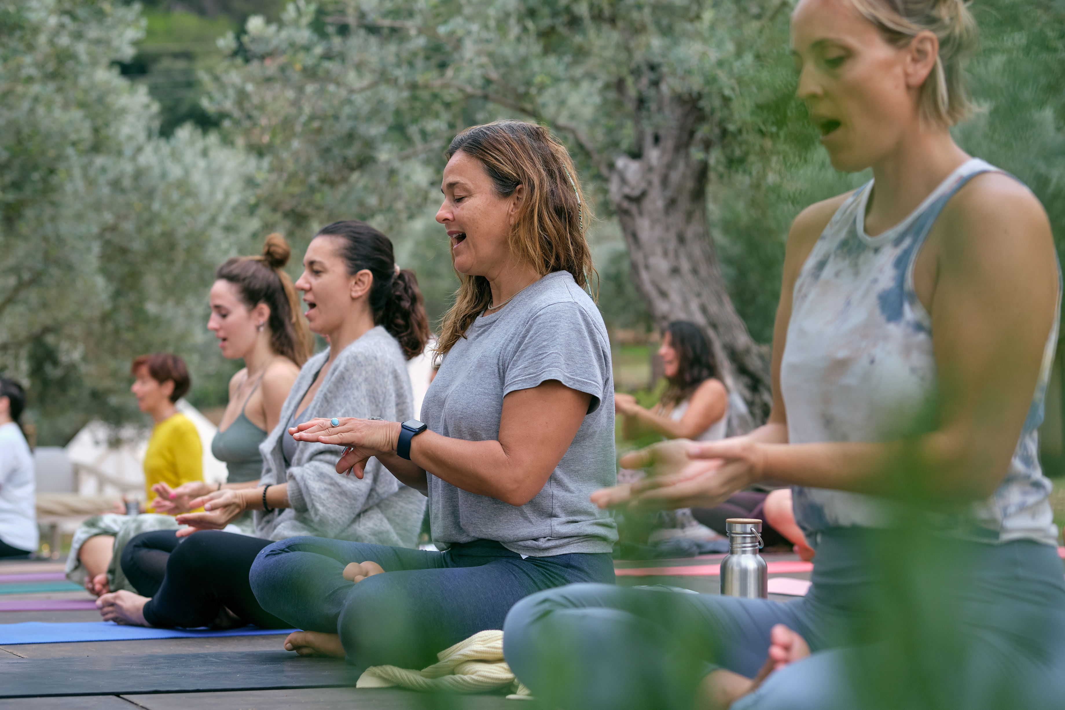 Women doing vocal exercises during yoga session